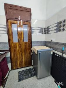 a wooden door in a room with a small refrigerator at MK Devbhoomi Homestay in Kandikhal