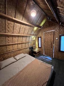 a bedroom with a bed in a room with a brick wall at The Twins Sunset Bungalow in Ekas