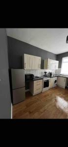 een keuken met witte apparatuur en een houten vloer bij 2BR Apt By Eason Stays Short Lets Warrington in Warrington