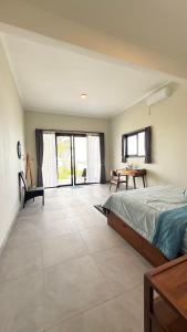 a bedroom with a large bed and a table at Ocean Daze Villa Yehsumbul in Jembrana +27 photos