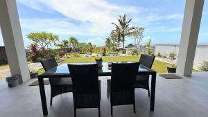 a black dining table and chairs on a patio at Ocean Daze Villa Yehsumbul in Jembrana