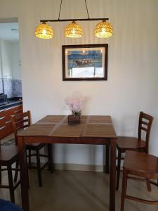 a dining room table with chairs and two lights at Namaste sea view apartment in Canacona