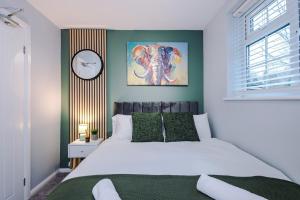 a bedroom with a bed and a clock on the wall at 2 BDR House By Eason Stays Short Lets Stockport in Stockport