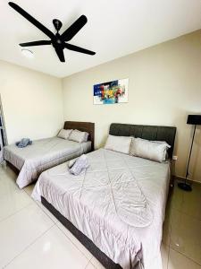 two beds in a bedroom with a ceiling fan at Homestay Babah - Private Chalet in Malacca