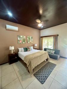 een slaapkamer met een groot bed en een bank bij Villa Tucan in Fortuna