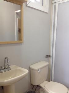 ein Badezimmer mit Toilette, Waschbecken und Spiegel in der Unterkunft Hotel Galeria & Boutique in Mexiko-Stadt