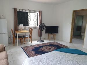 a living room with a bed and a table at Cambridge Heights Guest House in Port Maria