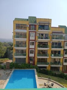 an apartment building with a swimming pool in front of it at Namaste sea view apartment in Canacona
