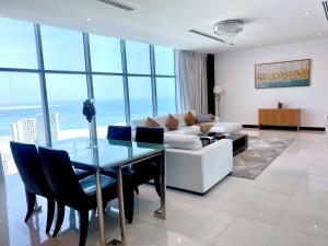 a living room with a glass table and a white couch at Seef Residence in Seef