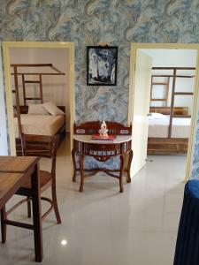a room with two beds and a table with a chair at Namaste sea view apartment in Canacona +2 photos