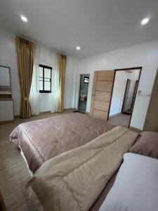a large bedroom with a large bed in it at Bancha white house in Ban Bo Han