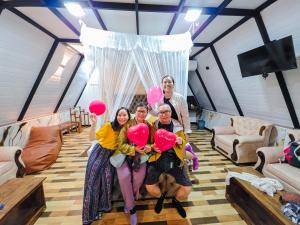 a group of three women holding pink heart balloons at White Moon Cabin & Cottage in Ella
