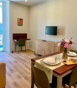 a living room with a table and a television at Sul Corso Sanremo in Sanremo