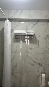 ein Badezimmer mit weißen Marmorwänden und einem Handtuchhalter in der Unterkunft Baadenberger stay D in Köln