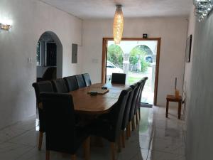 a dining room table with chairs and a laptop on it at Cambridge Heights Guest House in Port Maria