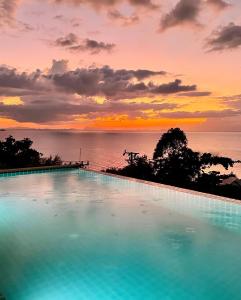 a large swimming pool with a sunset in the background at Tantawan sea view residence 山海居 in Salad Beach +239 photos