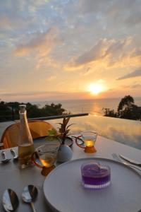 a table with a white plate and a bottle of wine at Tantawan sea view residence 山海居 in Salad Beach