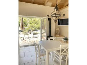 a kitchen and dining room with a white table and chairs at Private Hideaway in ut Island in Otočić Svršata Mala +16 photos