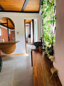 a living room with flowers on the wall at La Boca del Lagarto Lodge in Cucunubá