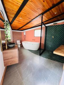a bathroom with a tub and a toilet and a sink at La Boca del Lagarto Lodge in Cucunubá