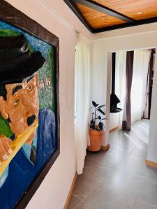 a painting of a man with a hat on a wall at La Boca del Lagarto Lodge in Cucunubá