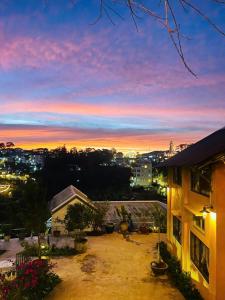 een uitzicht op de zonsondergang vanaf het balkon van een huis bij Hạ Hoàng Hôn House & Coffee in Da Lat