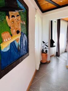 a painting of a man hanging on a wall at La Boca del Lagarto Lodge in Cucunubá +11 photos