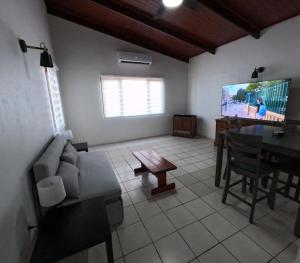 a living room with a couch and a table and a tv at Palm Beach 278 in Palm-Eagle Beach