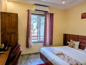 a bedroom with a bed and a desk and a window at Ganga Yamuna View in Prayagraj +42 photos