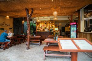 a restaurant with wooden tables and people sitting at tables at Prime Time Hotel in Unawatuna