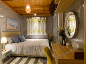 a bedroom with a bed and a table and a mirror at Beach Gardens Thasala 1 Bed in Ban Pak Nam Pak Duat