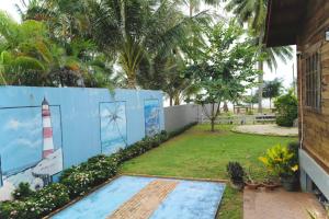 a fence with a mural of a lighthouse on it at Beach Gardens Thasala 1 Bed in Ban Pak Nam Pak Duat