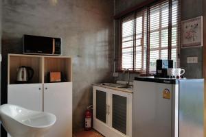 a kitchen with a refrigerator and a microwave at Beach Gardens Thasala 1 Bed in Ban Pak Nam Pak Duat +7 photos