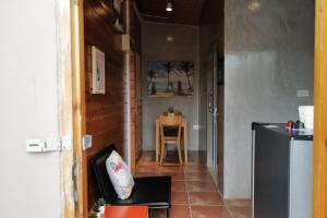 a hallway with a table and a chair in a room at Beach Gardens Thasala 1 Bed in Ban Pak Nam Pak Duat