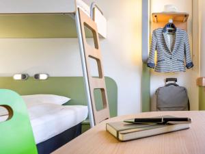 a bedroom with a bunk bed and a desk with a book at Hôtel Inn Design Issoudun in Issoudun
