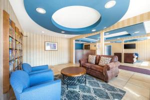 een woonkamer met twee stoelen, een bank en een tafel bij Suburban Studios Branson On The Strip in Branson