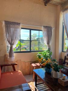 een woonkamer met een tafel en een groot raam bij Hạ Hoàng Hôn House & Coffee in Da Lat