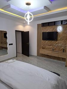 a bedroom with a bed and a flat screen tv at Diolux Serviced Apartments in Lekki