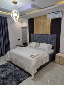 a bedroom with a large bed with a blue headboard at Diolux Serviced Apartments in Lekki