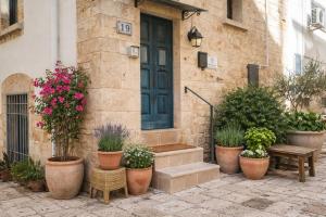 a house with potted plants in front of a door at Dimora delle Badesse in Conversano