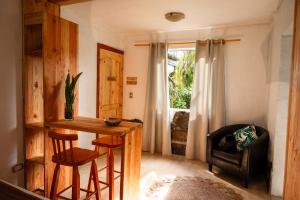 a room with a table and a chair and a window at PARAÍSO Sunset Bungalows in Hanga Roa