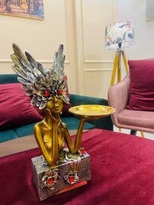 a gold statue of an angel sitting on a table at The Winestone Escape in Māripat