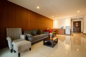 a living room with a couch and a chair and a table at Baywalk Residence Pattaya in Pattaya Central