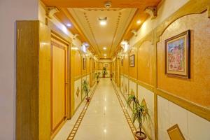 a hallway with a long corridor with plants in it at Collection O Dandiya Bazar Formerly Vrundavan Residency in Vadodara