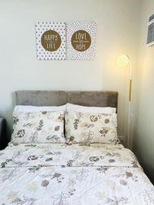 een slaapkamer met een bed met twee kussens en een bordje bij 12F Condo at The Loop Tower Limketkai Center CDO in Cagayan de Oro