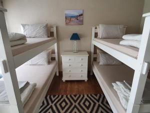 a room with two bunk beds and a night stand at Waves End Holiday Home in Southbroom