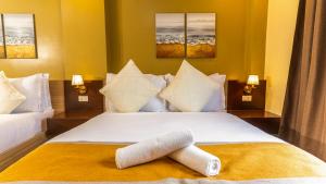 a bedroom with a bed with a towel on it at Hollywood Hotel Puerto Princesa in Puerto Princesa City