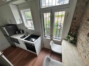 a small kitchen with a sink and two windows at 2 Bedroom Pyrmont Terrace House in Sydney +3 photos