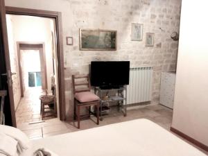 a living room with a television and a chair at Dimora delle Badesse in Conversano