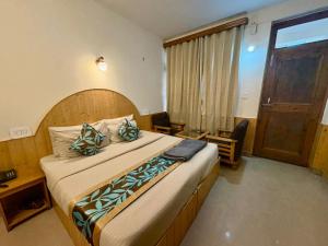 una camera da letto con un letto grande con testiera in legno di Hotel Purnima by smugglers hotels a Kasol